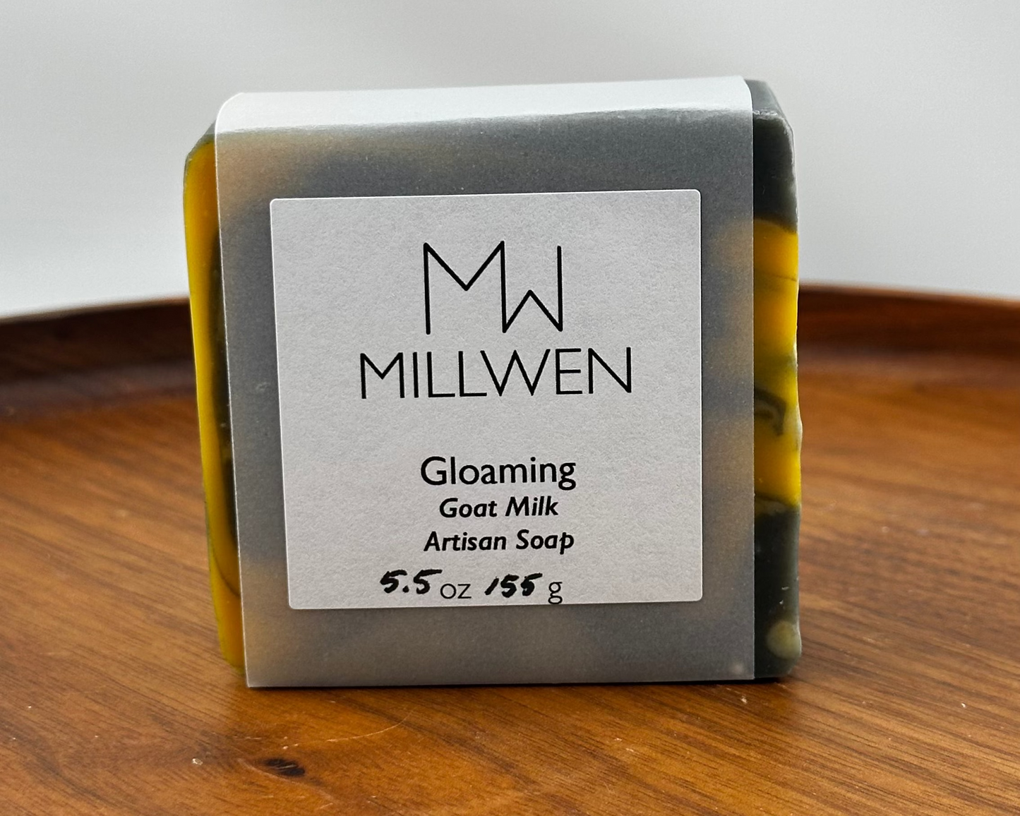 Bar of soap with a 'Millwen' label on a wooden surface